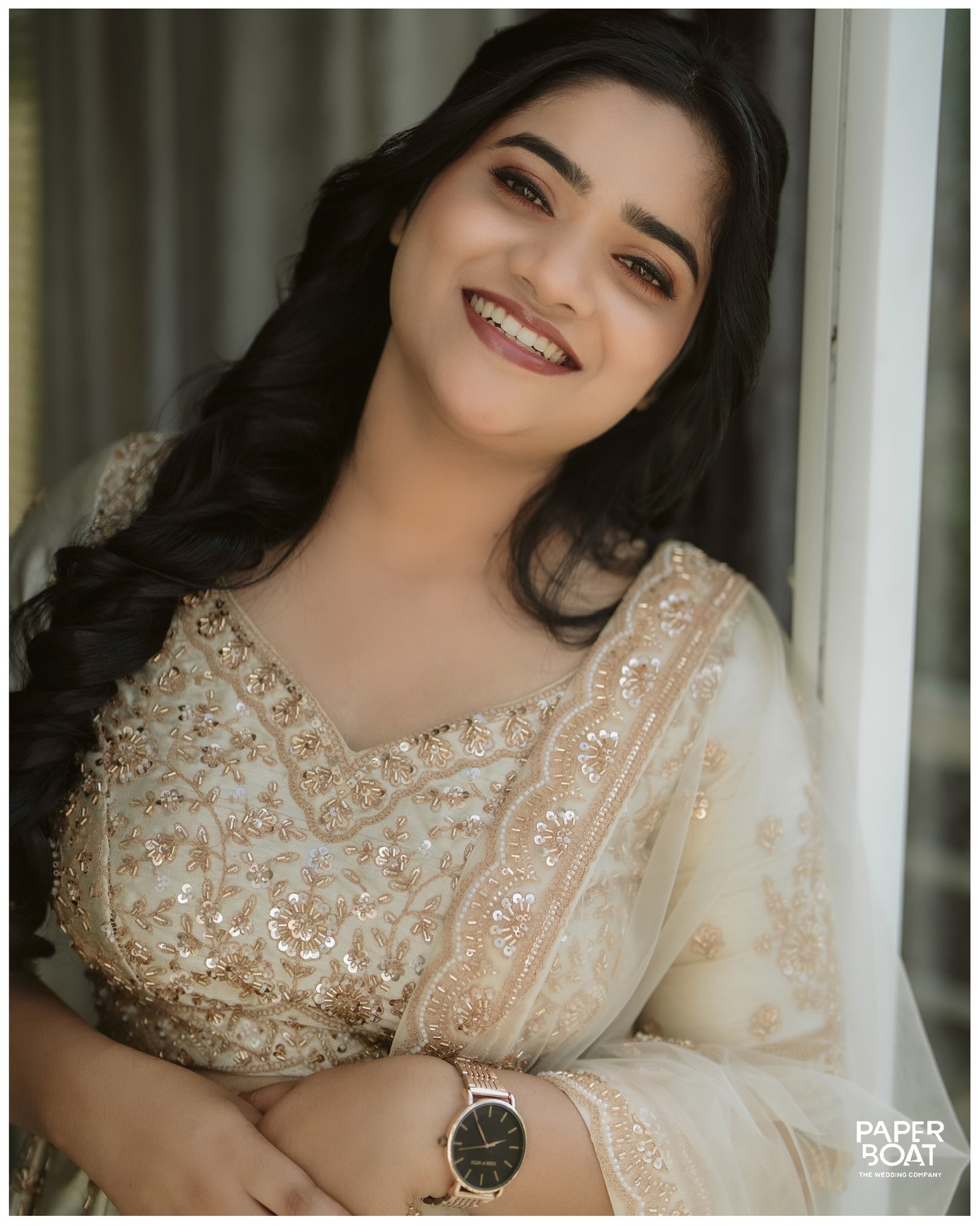 A bride smiling in soft window light