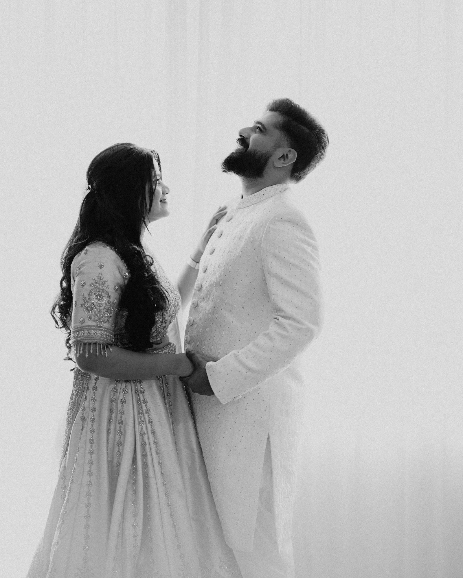 A couple laughing together in a timeless black-and-white portrait