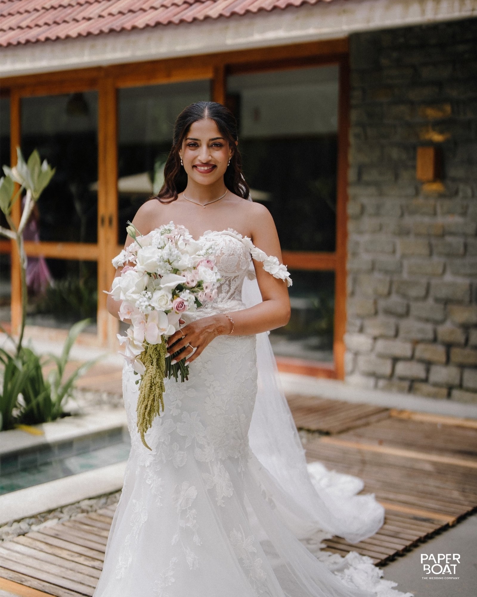 A bride holding a bouquet outside a rustic venue